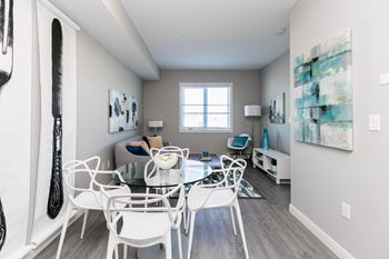 A dining room with a white table and chairs.
